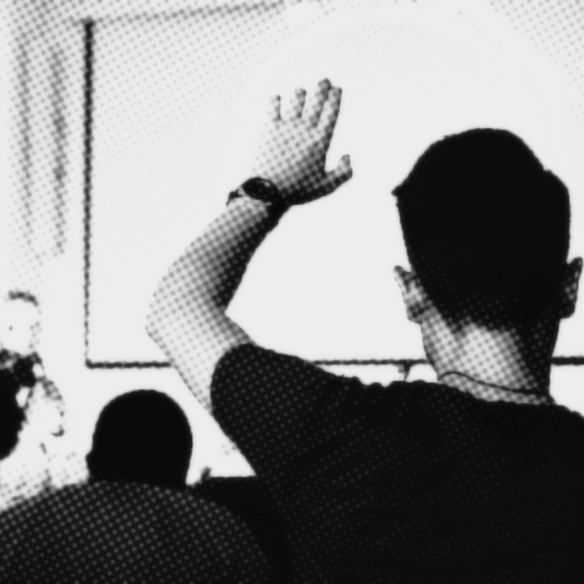 pessoa levanta a mão durante palestra